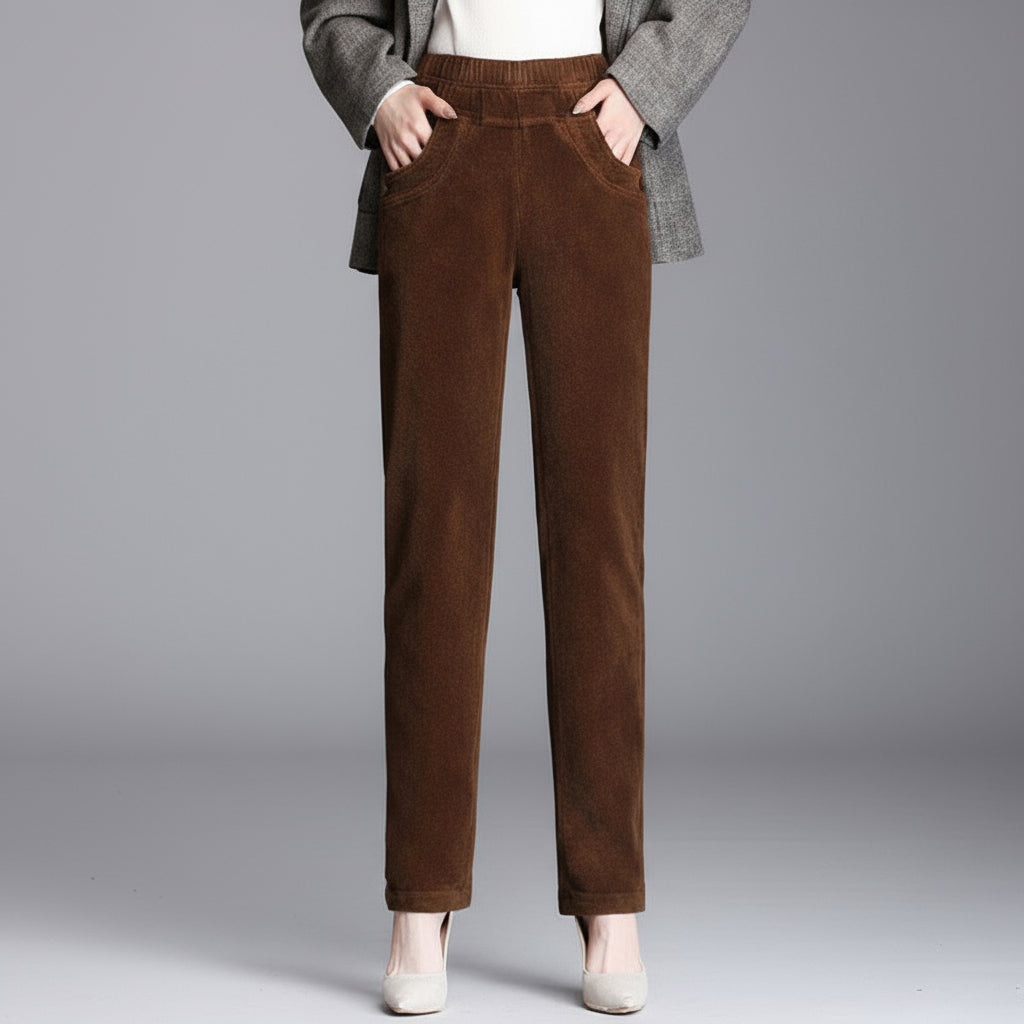 Brown corduroy pants worn by a person on a gray background