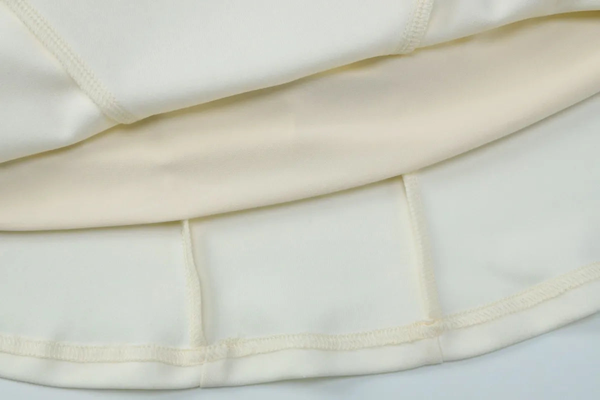 Close-up of a white garment with a gold trim on a light gray background