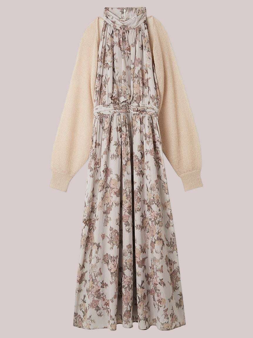 Floral dress with a beige cardigan on a light pink background
