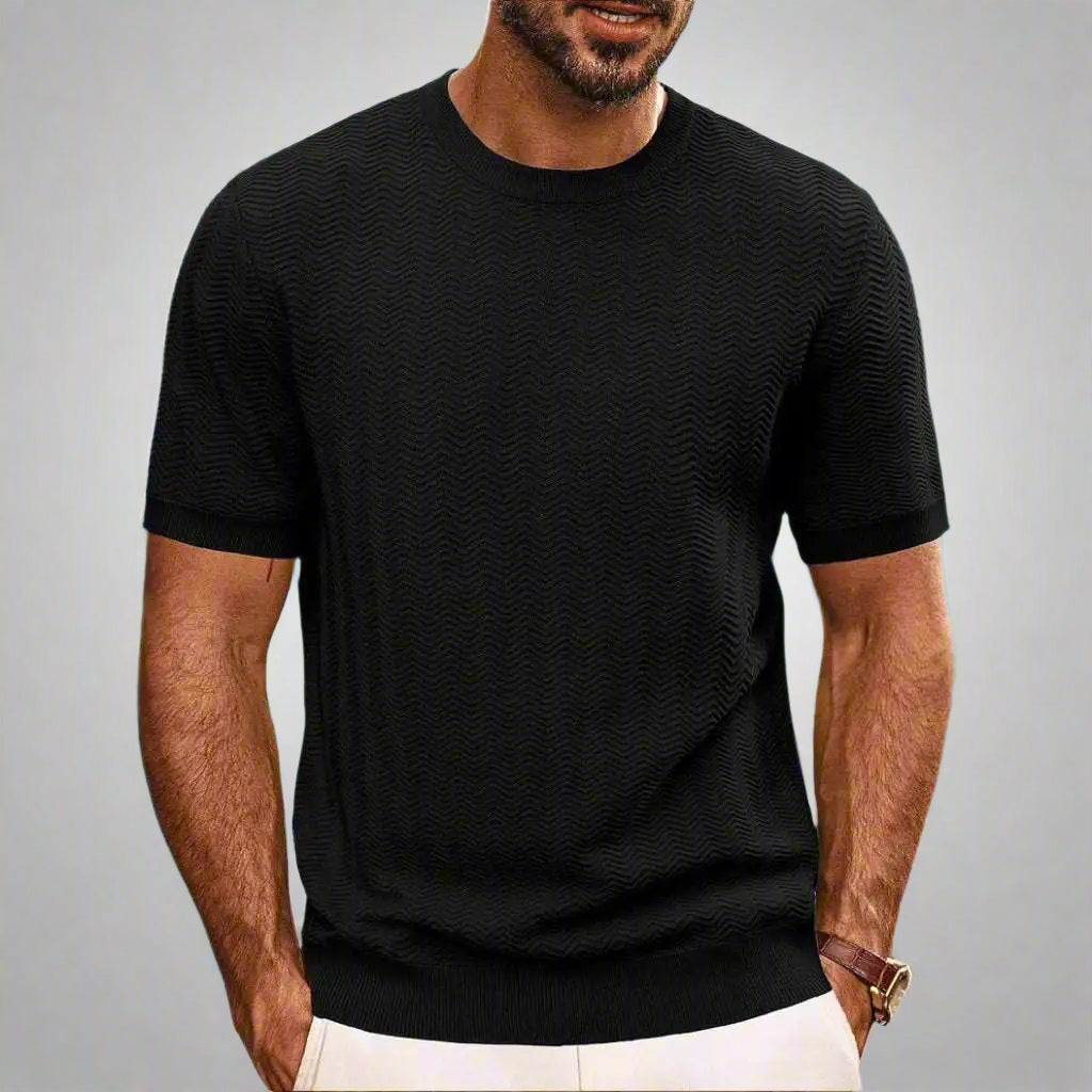 Man wearing a black t-shirt with a beach background