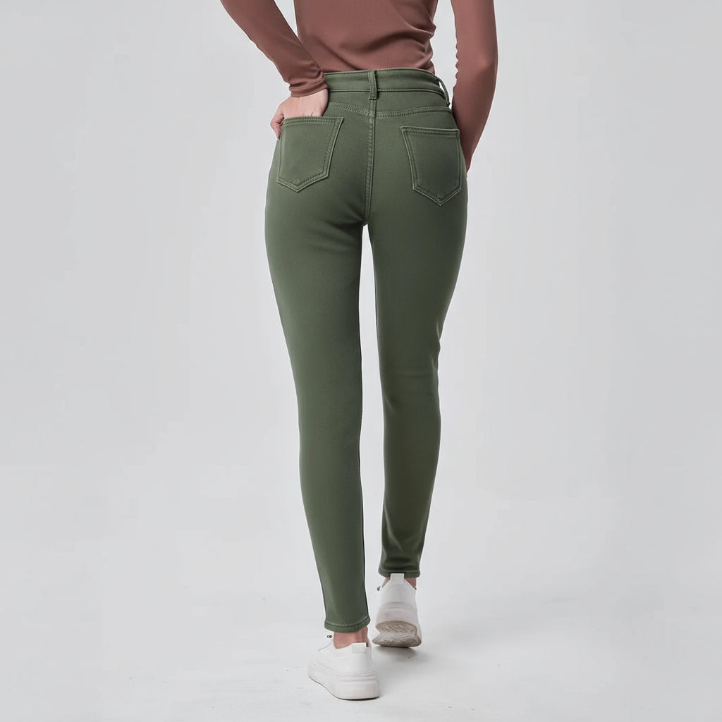 Person wearing green jeans on a plain background