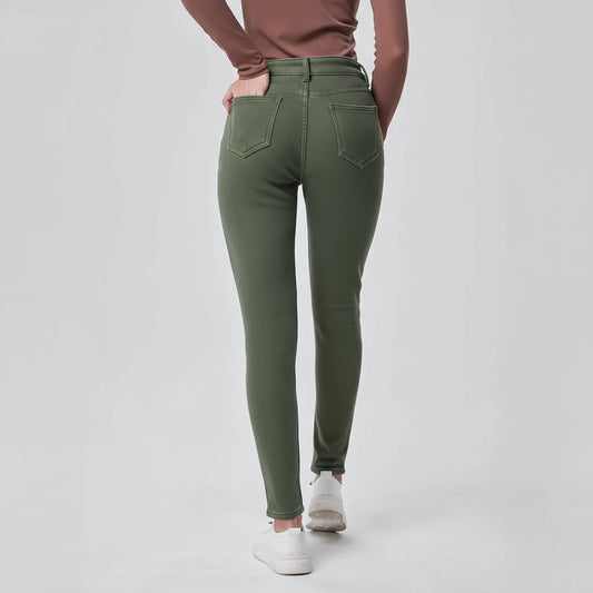 Person wearing green jeans on a plain background
