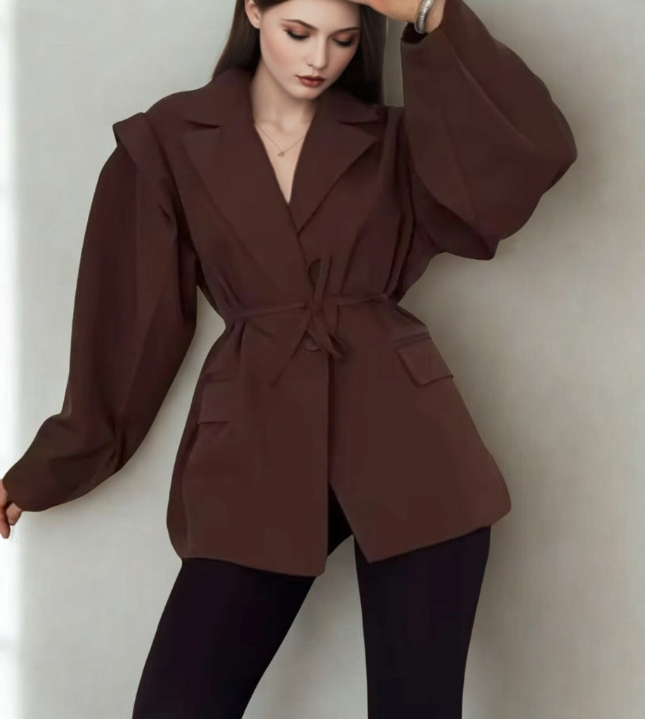 Woman wearing a brown coat against a plain background