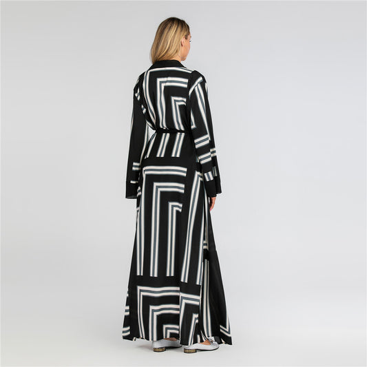 Woman wearing a black and white patterned dress on a plain background