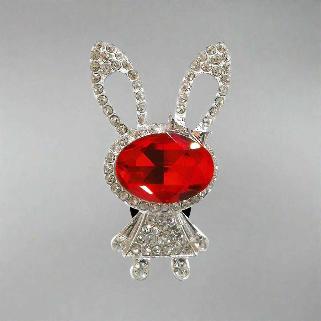 Bunny-shaped brooch with a red gem and rhinestone details on a white background