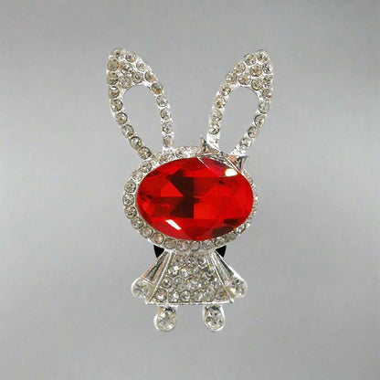 Bunny-shaped brooch with a red gem and rhinestone details on a white background