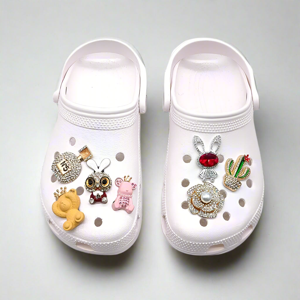 White clogs with decorative charms on a white background