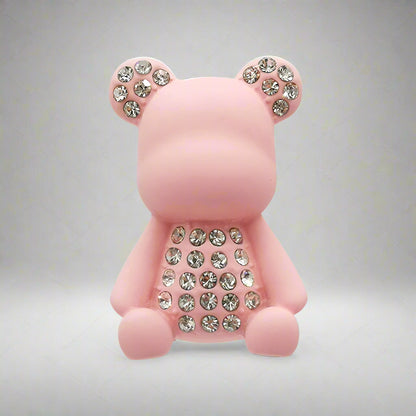 Pink teddy bear-shaped object with rhinestone details on a white background