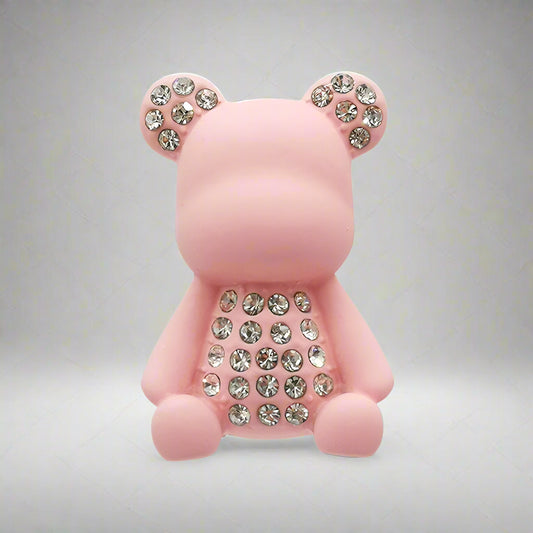Pink teddy bear-shaped object with rhinestone details on a white background