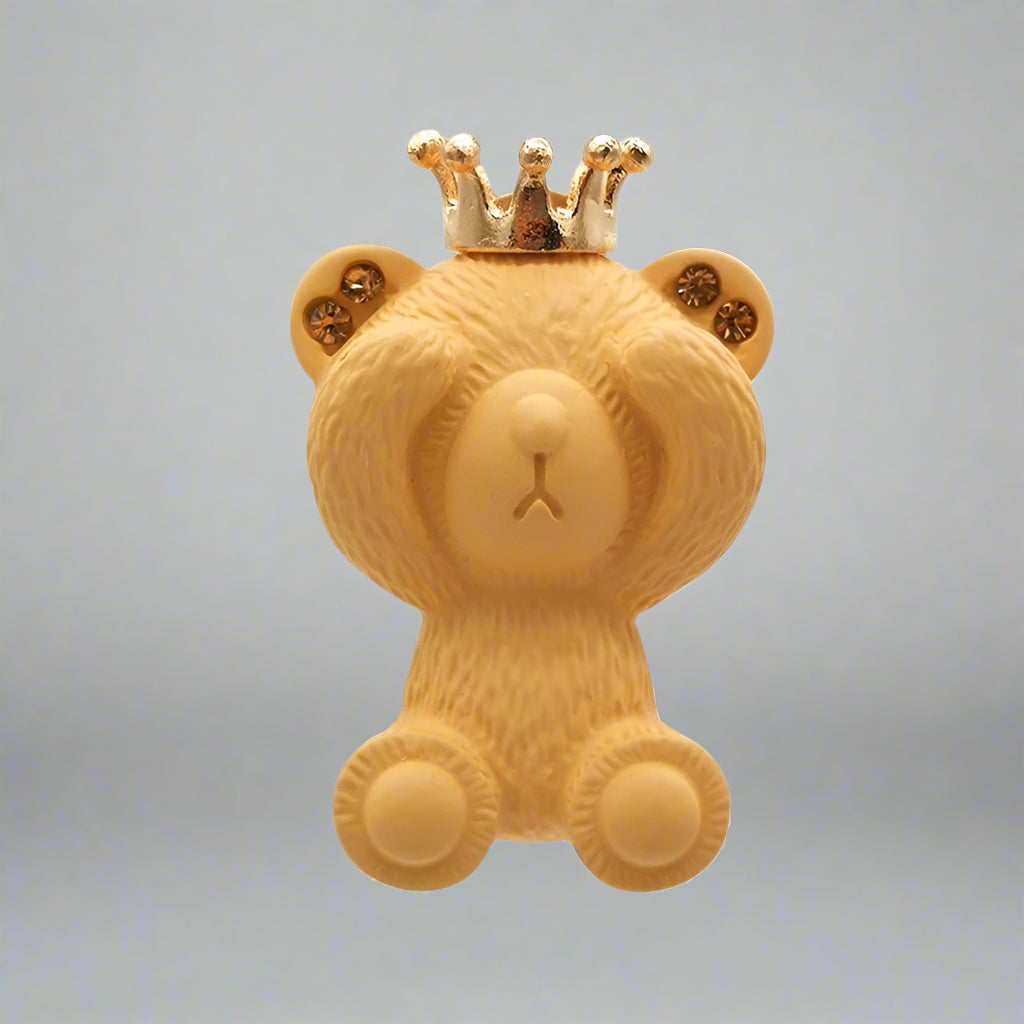 Yellow teddy bear with a gold crown on a white background