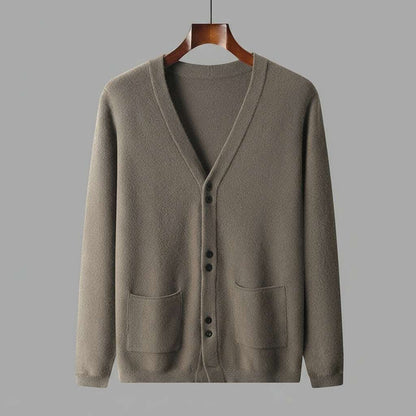 Brown cardigan on a hanger against a gray background
