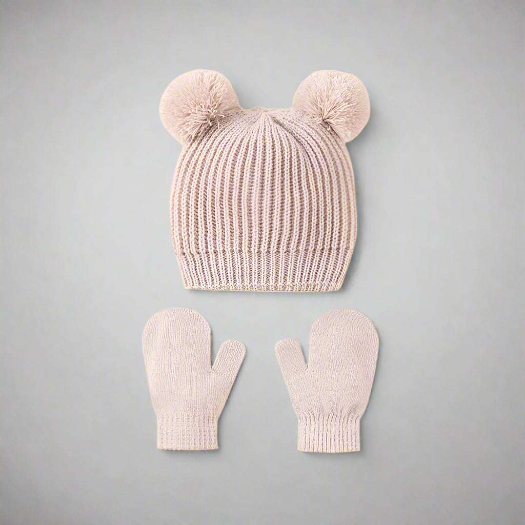 Knitted hat and mittens set with pom-poms on a white background