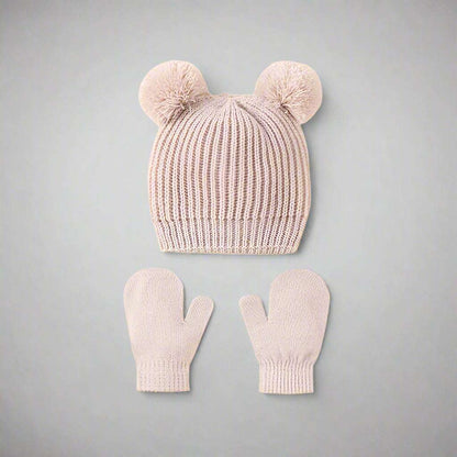 Knitted hat and mittens set with pom-poms on a white background