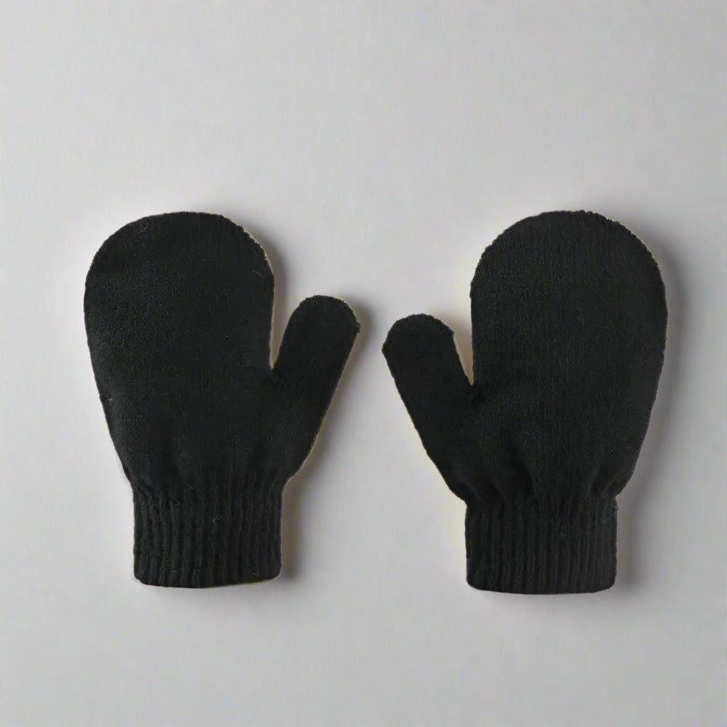 Pair of black mittens on a beige background
