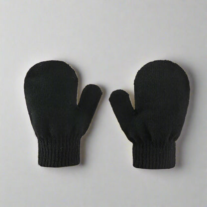 Pair of black mittens on a beige background