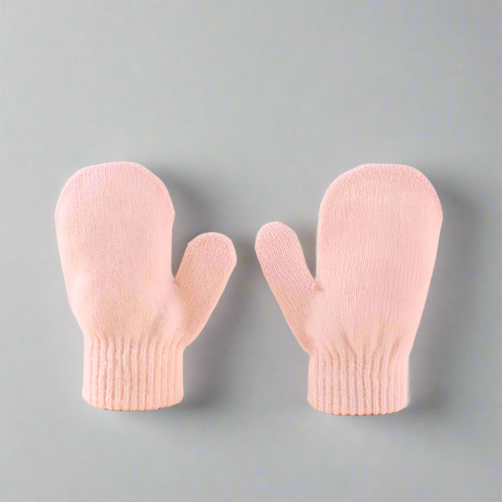 Pair of pink mittens on a beige background