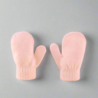 Pair of pink mittens on a beige background