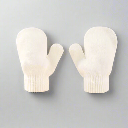 Pair of white baby mittens on a beige background