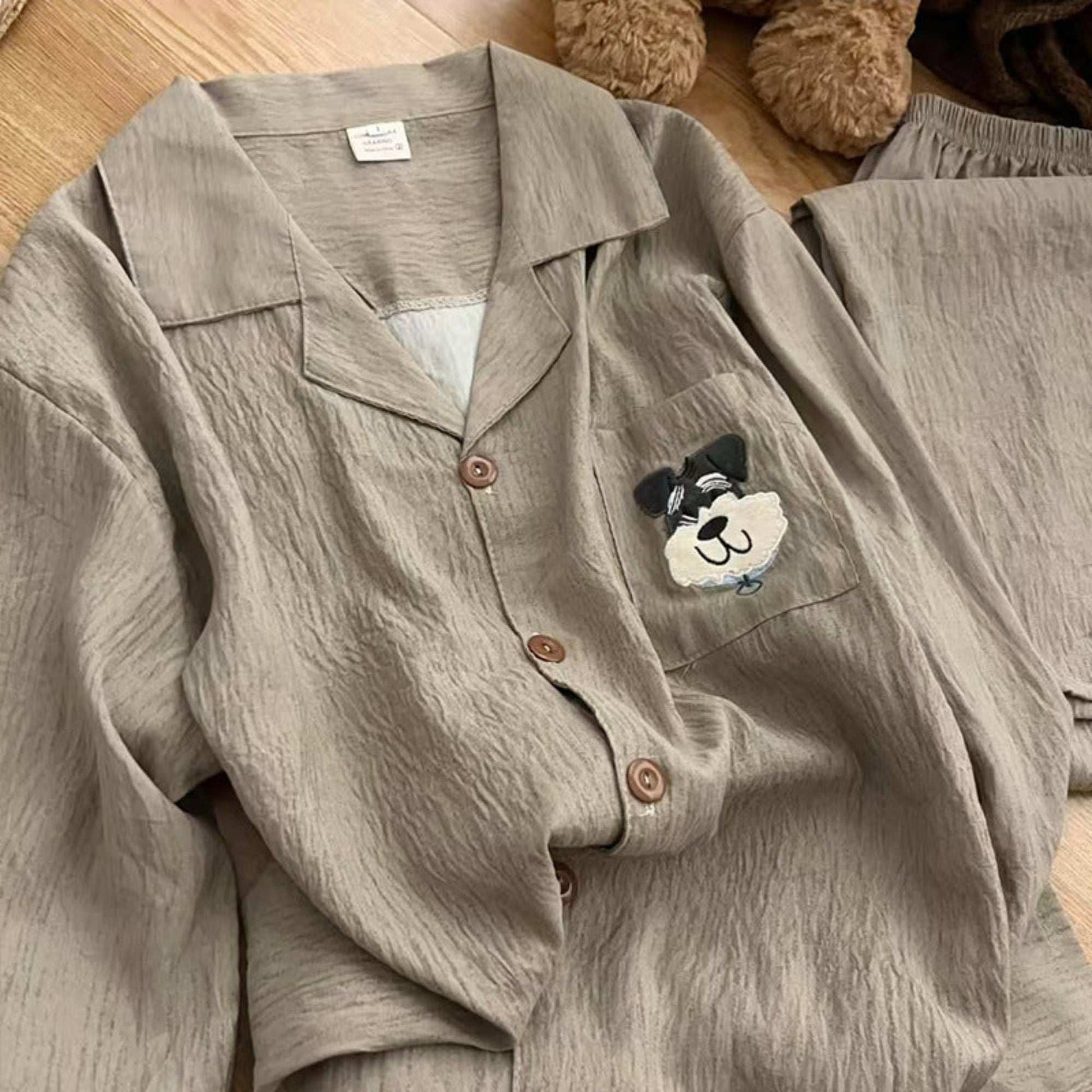 Gray pajama set with a cartoon dog patch on a wooden floor.