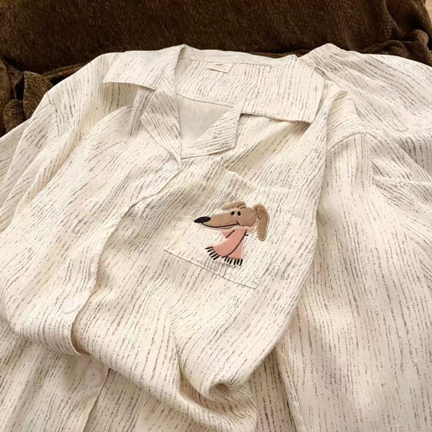 Light-colored textured shirt with a dog patch on a brown background