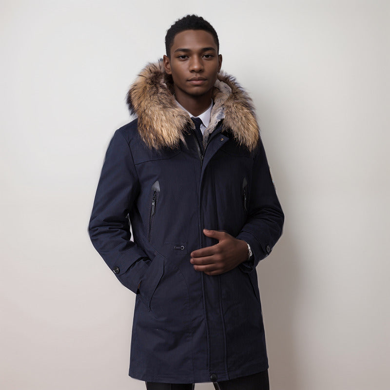 Man wearing a navy coat with a fur-lined hood against a plain background