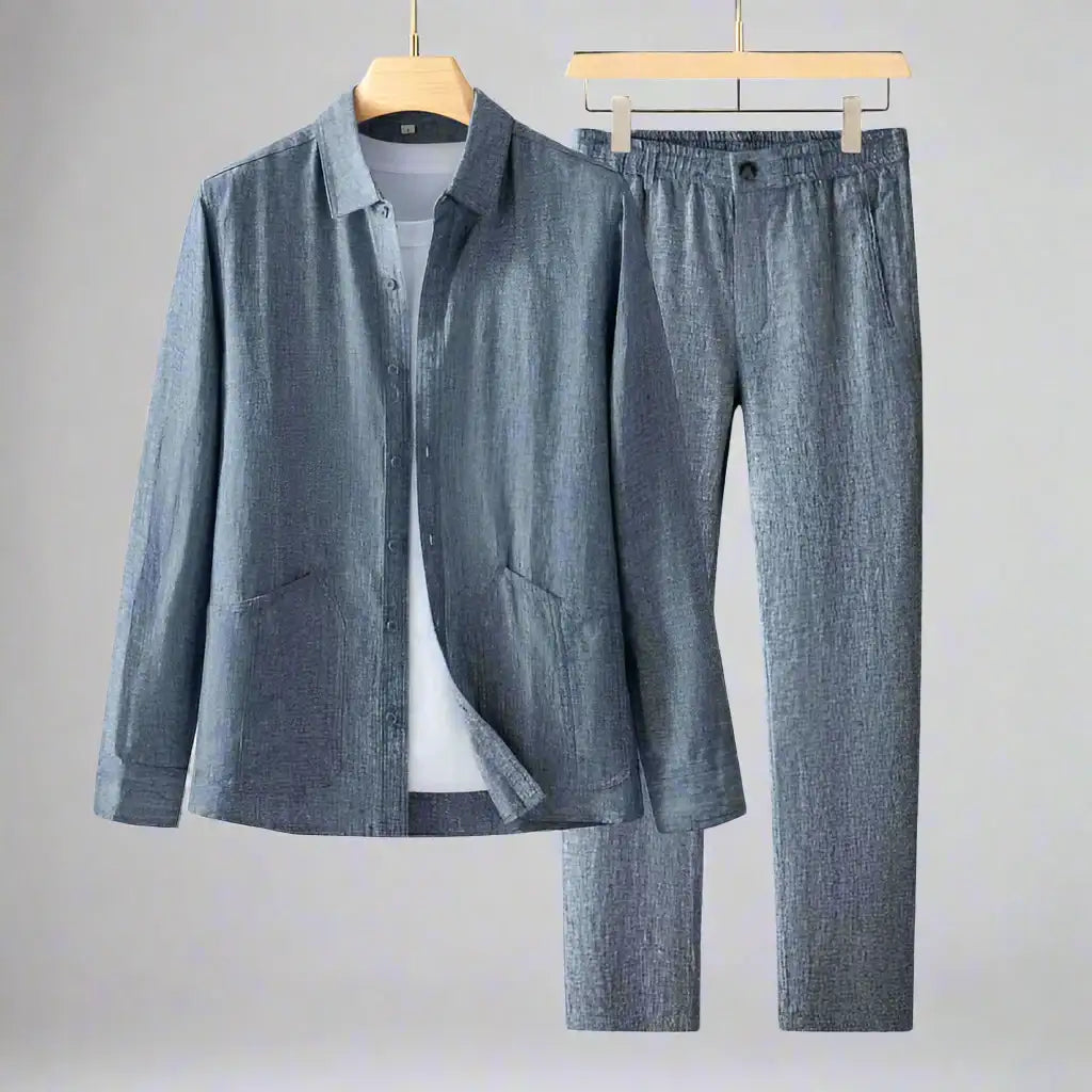Blue denim shirt and pants on hangers against a gray background