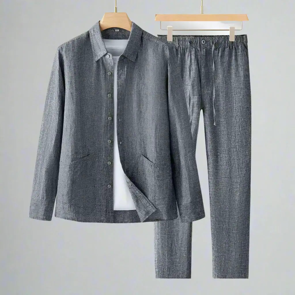Gray shirt and pants set on hangers against a gray background
