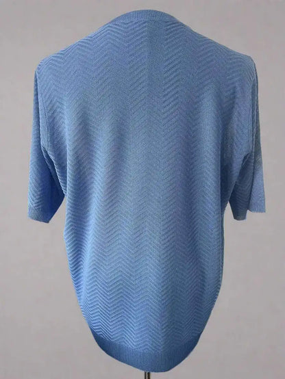 Blue knitted sweater on a mannequin against a gray background