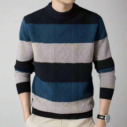 Person wearing a striped sweater with blue, gray, and black colors on a dark background