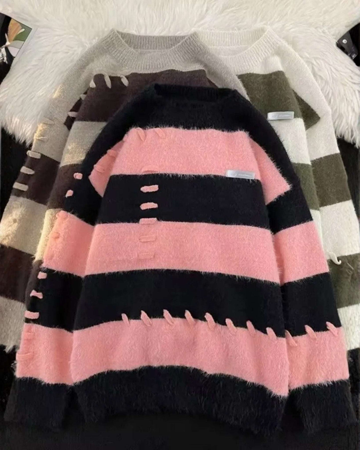 Men's patchwork knit sweater with pink and black striped color blocking, fuzzy distressed texture, crew neck pullover style