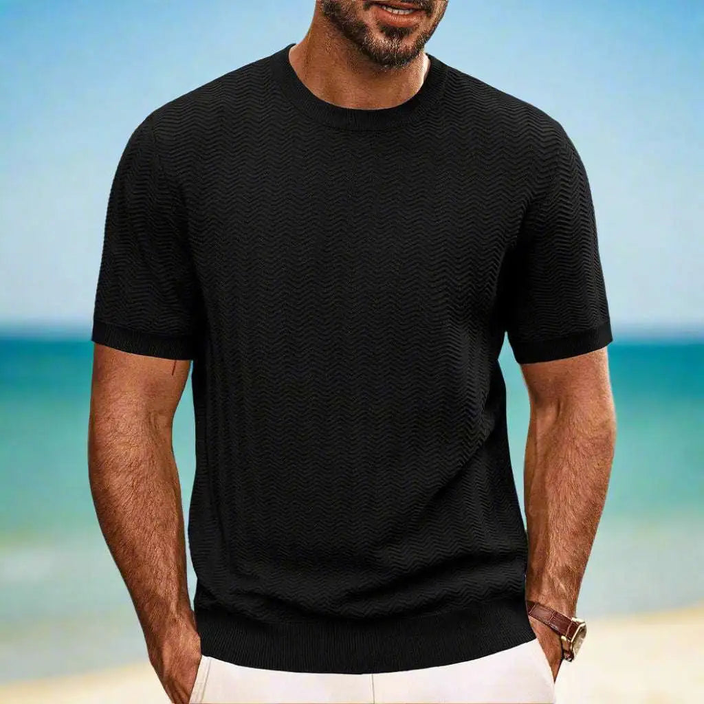 Man wearing a black t-shirt with a beach background