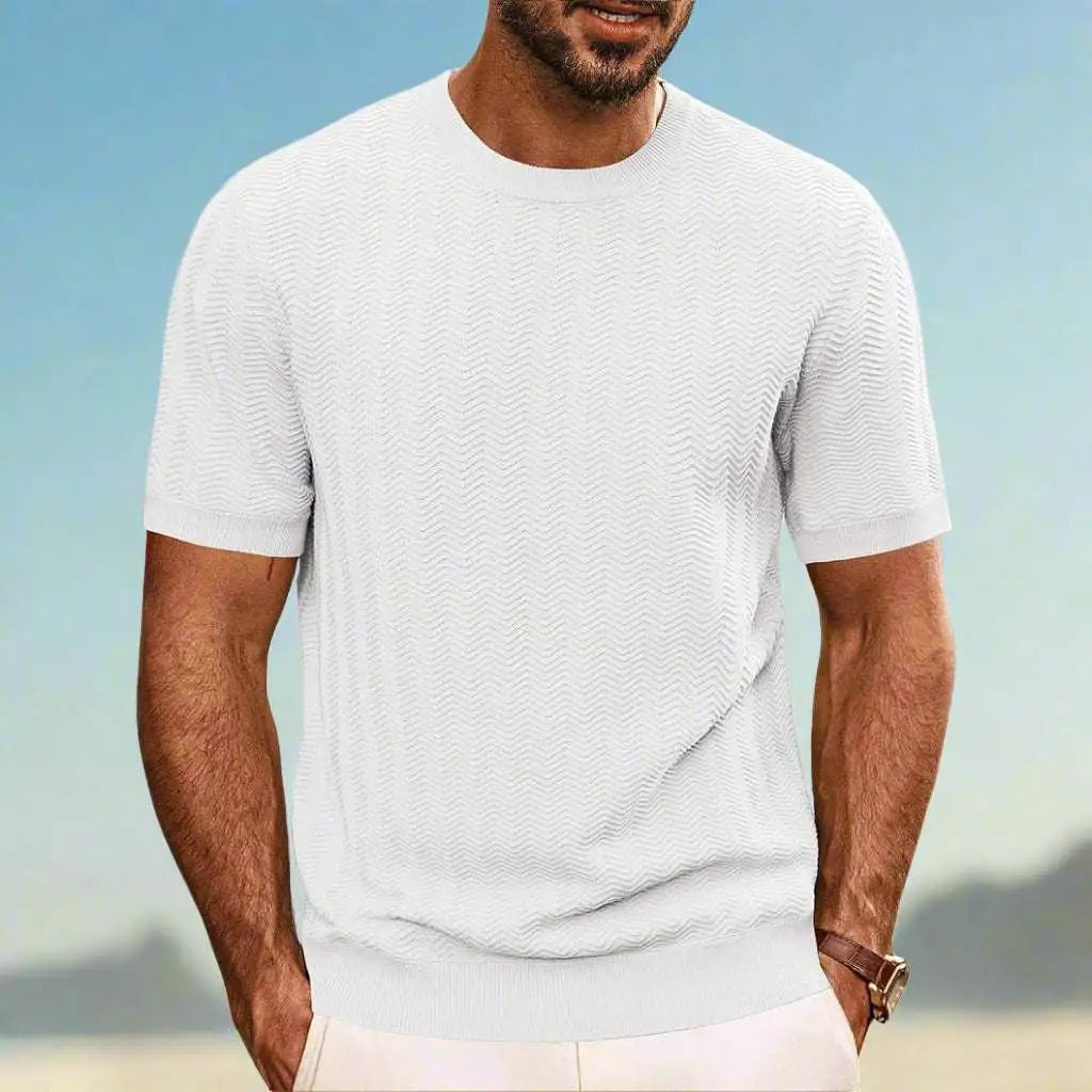 Man wearing a light gray t-shirt against a blurred natural background