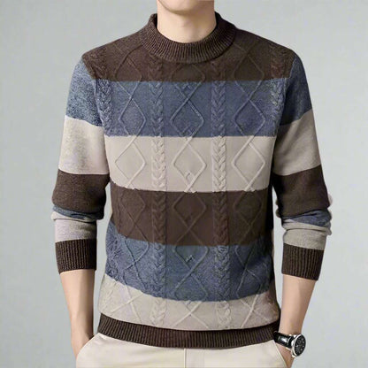 Multicolored patterned sweater worn by a person on a dark background