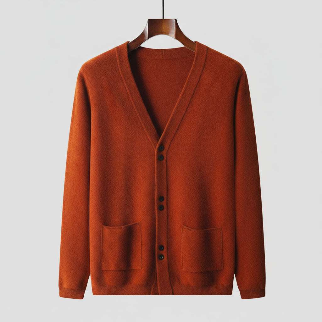 Orange cardigan on a wooden hanger against a gray background