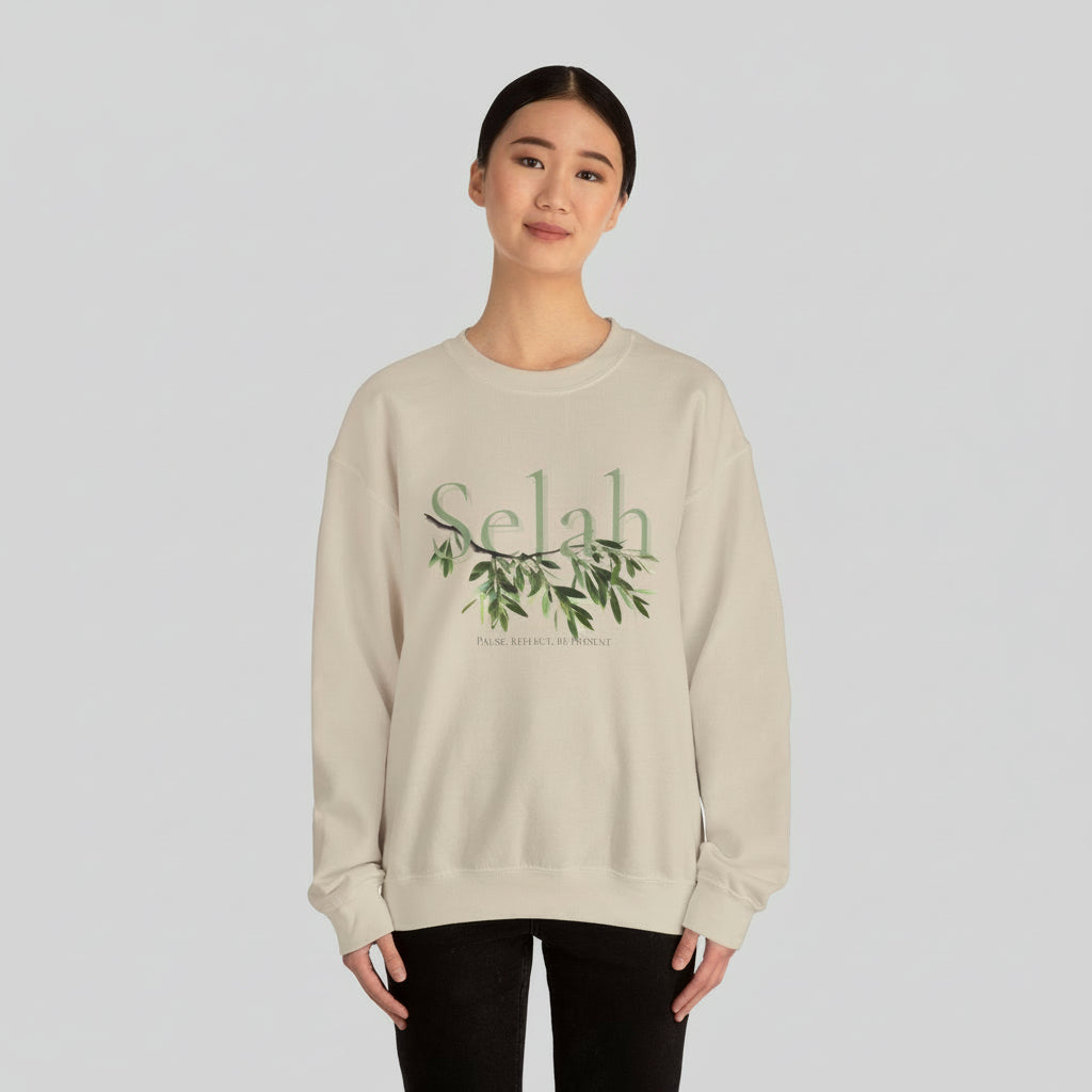 Person wearing a beige sweatshirt with 'Selah' and olive branch design on a white background