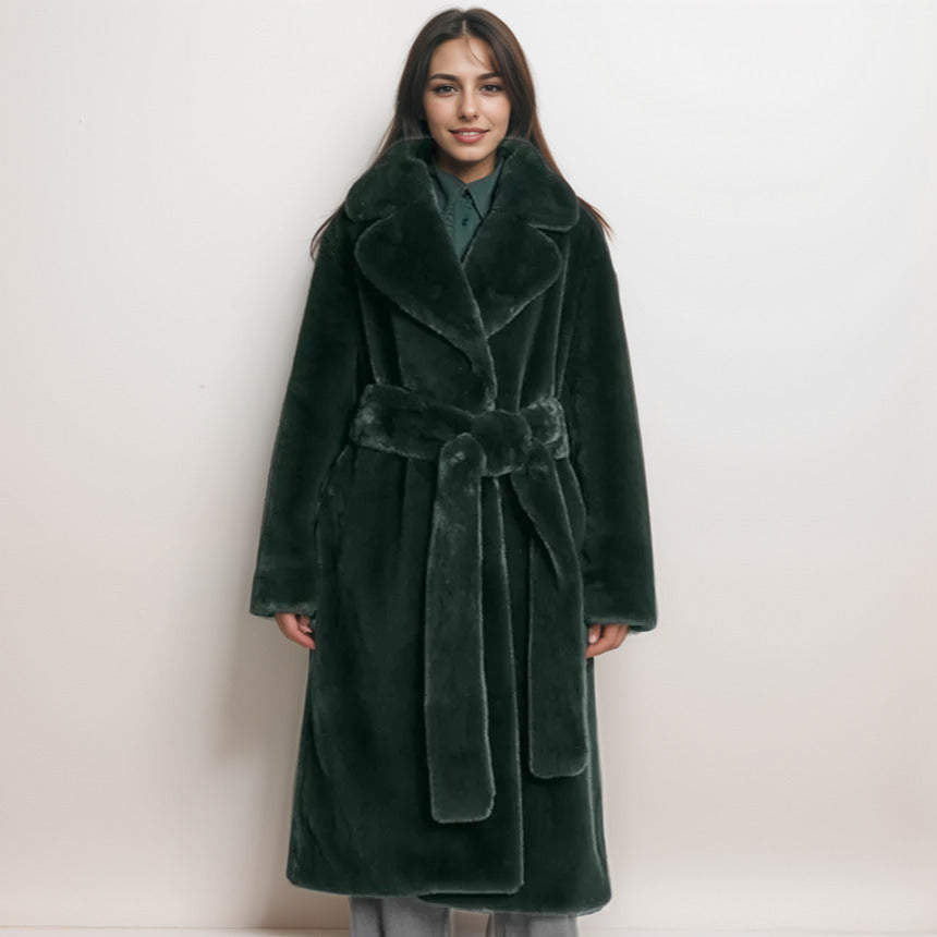 Woman wearing a long green coat with a belt on a white background