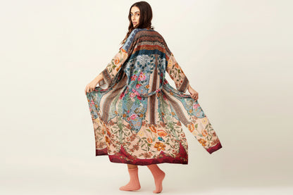 Woman wearing a colorful floral dress and red hat on a white background