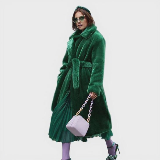 Model wearing a green robe holding a white bag on a white background